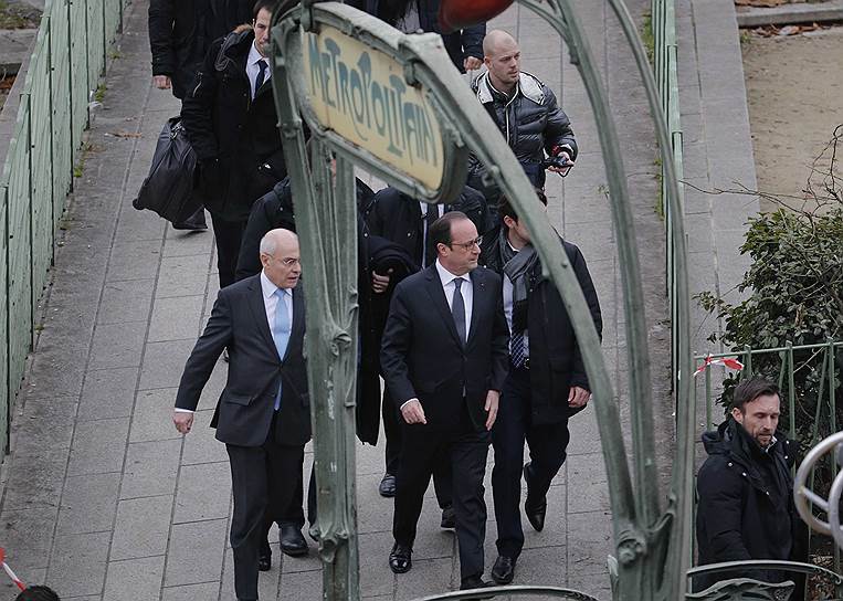 Прибывший на место трагедии происшествия президент Франсуа Олланд (в центре) выразил свою солидарность с жертвами покушения, назвав расстрел редакции терроризмом
