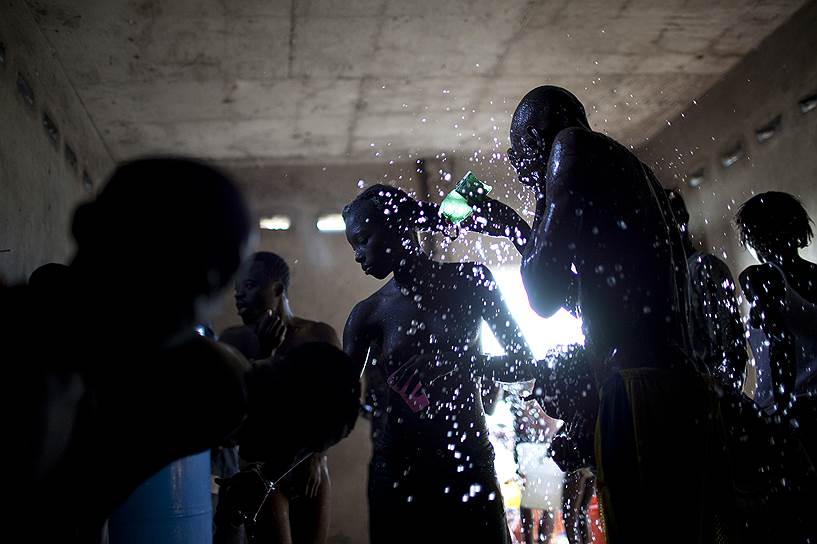 Гуманитарную помощь из аэропорта Порт-о-Пренса доставляли по воздуху. Однако процесс был организован плохо — продовольствие просто бросали в толпу
&lt;br>
На фото: жители Гаити умываются в одном из домов в Порт-о-Пренсе