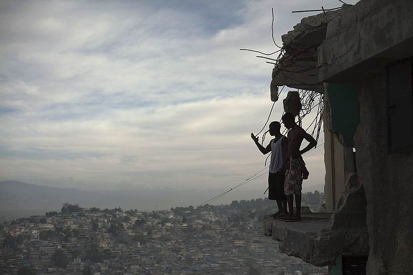 В день землетрясения в столице Гаити Порт-о-Пренсе были разрушены тысячи жилых домов и практически все больницы.
&lt;br>
На фото: жители Гаити в разрушенном доме