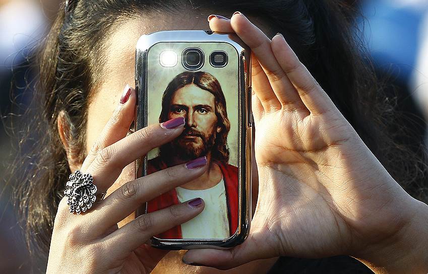 Коломбо, Шри-Ланка. Верующий снимает на свой смартфон во время приезда папы римского для проведения публичной мессы
