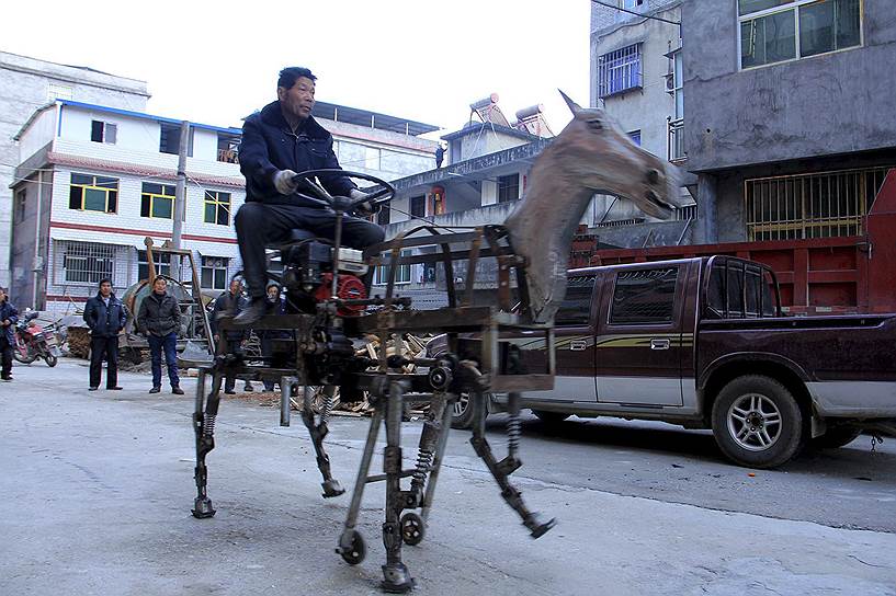 Шиянь, Китай. Изобретатель Су Даочэн едет на своей механической лошади по улице города