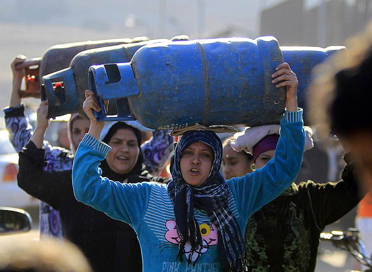 Каир, Египет. Женщины с пустыми газовыми баллонами в очереди на заправочной станции