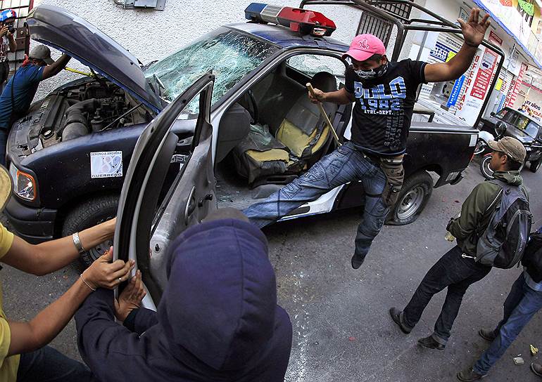 Чилпансинго, Мексика. Демонстранты, добивающиеся ясности в пропаже 43 студентов, разбивают полицейскую машину во время акции возле здания федерального суда