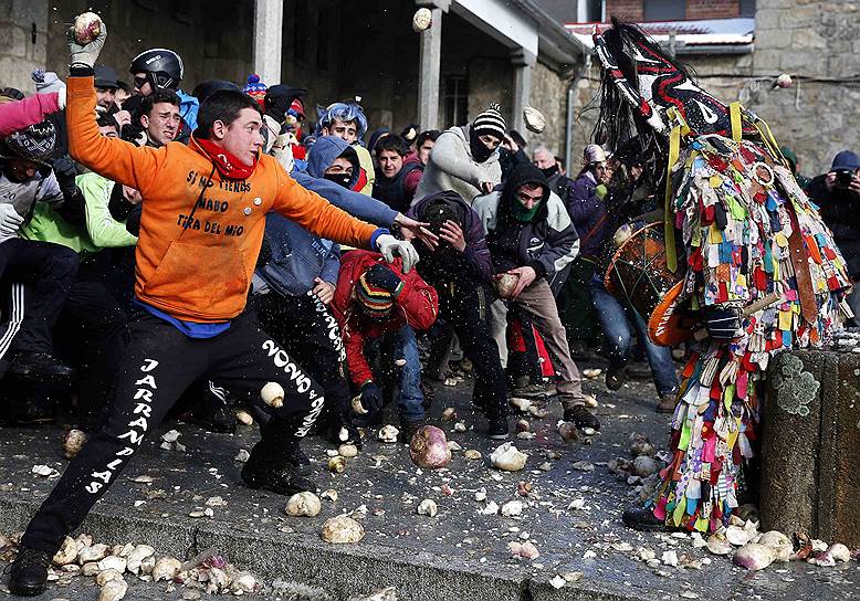 Пиорналь, Испания. Местные жители и туристы закидывают репой человека в маске демона во время традиционного праздника