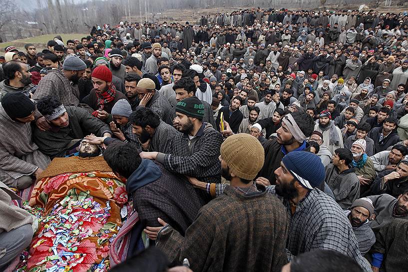 Сринагар, Индия. Кашмирцы собрались вокруг тела боевика, который был убит индийским солдатом в перестрелке, во время его похорон в Хандуре
