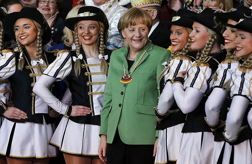 Берлин, Германия. Канцлер Германии Ангела Меркель позирует с участниками немецкого карнавала