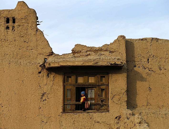 Кабул, Афганистан. Ребенок выглядывает из окна дома