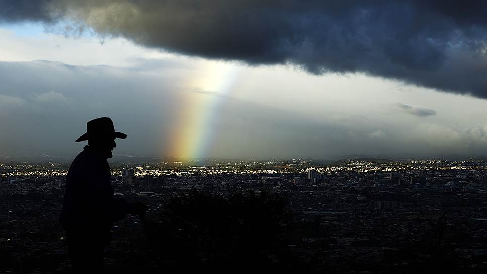 Сан-Хосе, Коста-Рика. Мужчина на фоне радуги после дождя