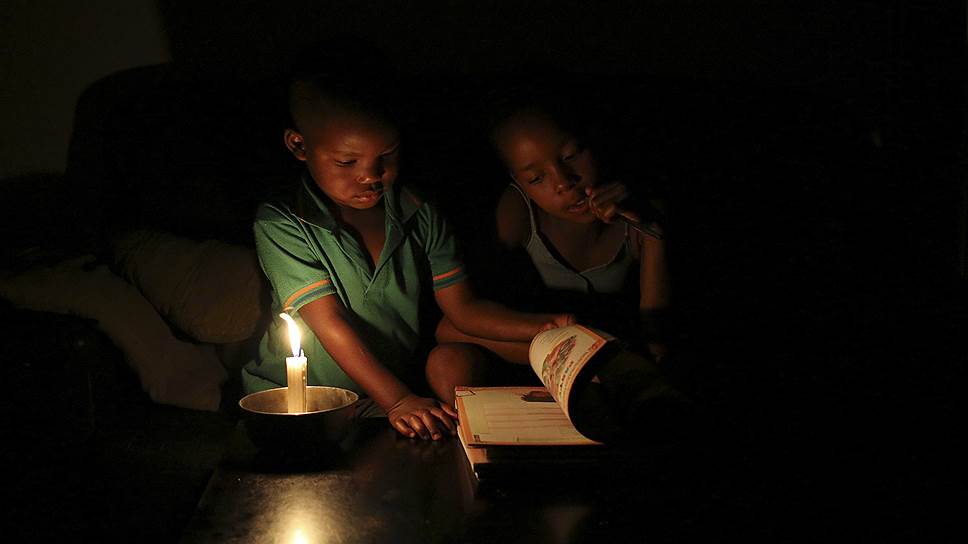 Совето, ЮАР. Дети над книжкой во время веерных отключений электроэнергии компанией Eskom 