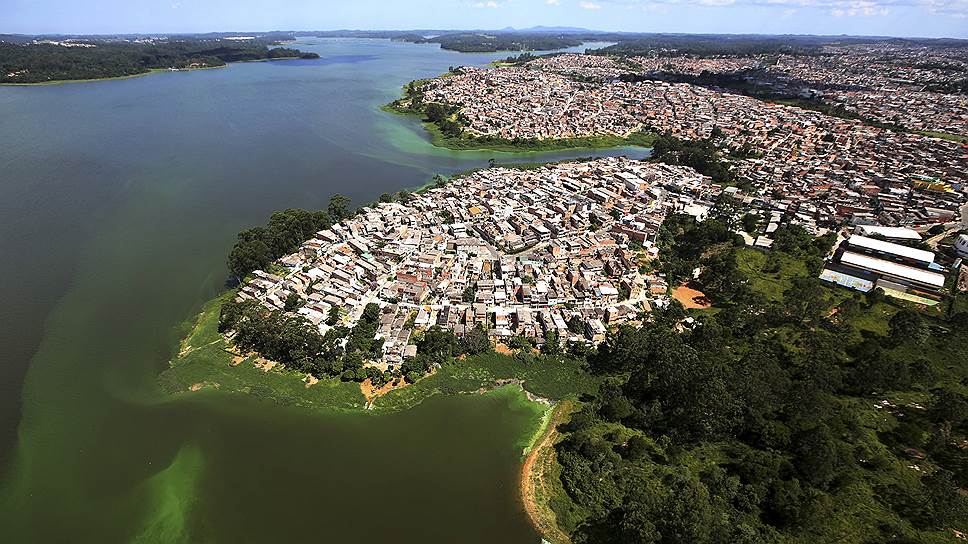 Сан-Паулу, Бразилия. Вид на незаконно построенные трущобы на берегу загрязненного  водохранилища Billings