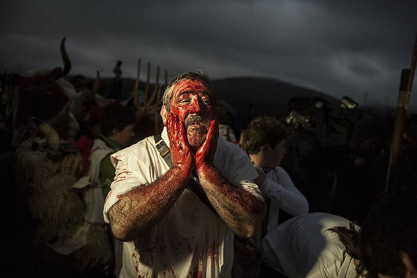 Альсасуа, Испания. Участник карнавала покрывает лицо кровью животных