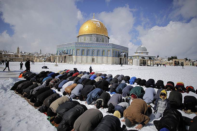 Иерусалим, Израиль. Палестинцы молятся перед заснеженным Куполом над Скалой — исламским святилищем на Храмовой горе 