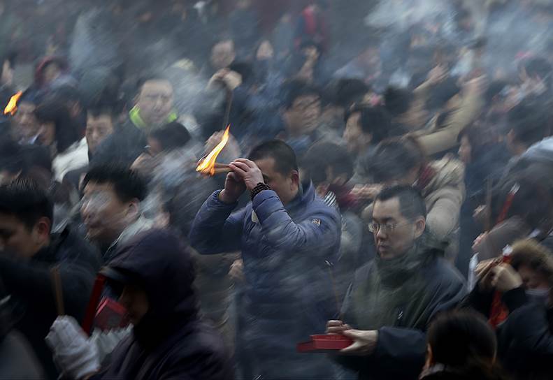 Пекин, Китай. Мужчина молится в храме в первый день китайского лунного Нового года