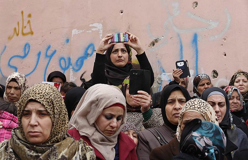 Вифлеем, Палестина. Женщины снимают на мобильные устройства похоронную процессию 20-летнего местного жителя, застреленного израильскими солдатами