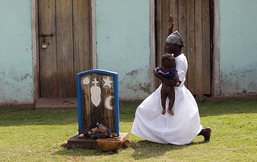 Гулу, Уганда. Участница Движения Святого Духа исполняет религиозный ритуал со своим ребенком на территории храма
