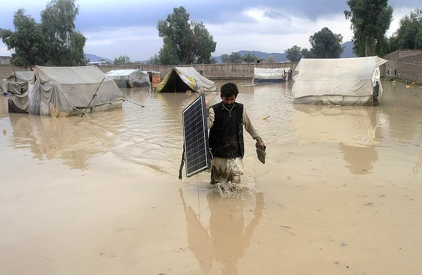 Провинция Нангархар, Афганистан. Мужчина с солнечной панелью во время наводнения, вызванного проливными дождями