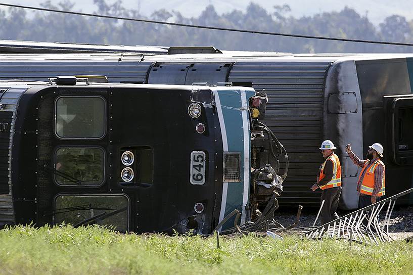 Окснард, штат Калифорния, США. Рабочий снимает на мобильный телефон последствия железнодорожной аварии. При столкновении пассажирского поезда с трактором, застрявшим на путях, пострадали более 30 человек