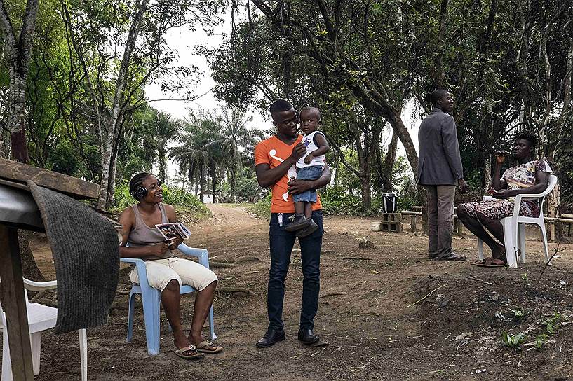 Валакор, Либерия. Муса Пабаи держит на руках своего сына Оливера впервые после того, как Муса вылечился от вируса Эболы