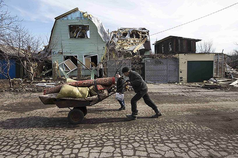 Дебальцево, Донецкая область, Украина. Мужчина перевозит свои вещи на тележке