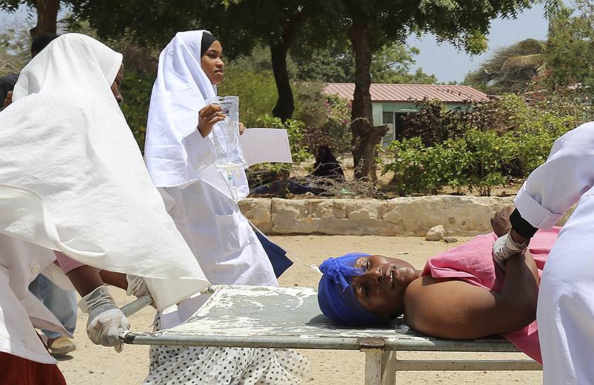 Могадишо, Сомали. Медики помогают женщине, раненой при атаке на президентский дворец