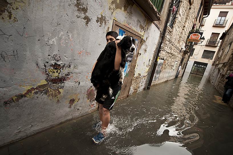 Тудела, Испания. Мальчик несет свою собаку по затопленной в результате затяжных дождей городской улице