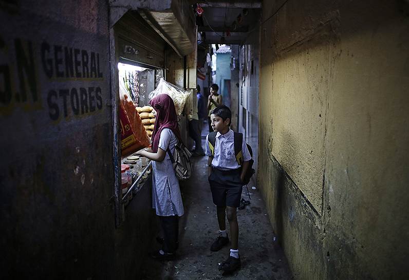Мумбаи, Индия. Школьник ранним утром на улице в трущобном районе города
