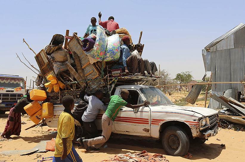 Могадишо, Сомали. Семья сомалийских беженцев толкает пикап с личными вещами. Власти страны закрыли лагерь для беженцев, в результате чего сотни людей остались без крова