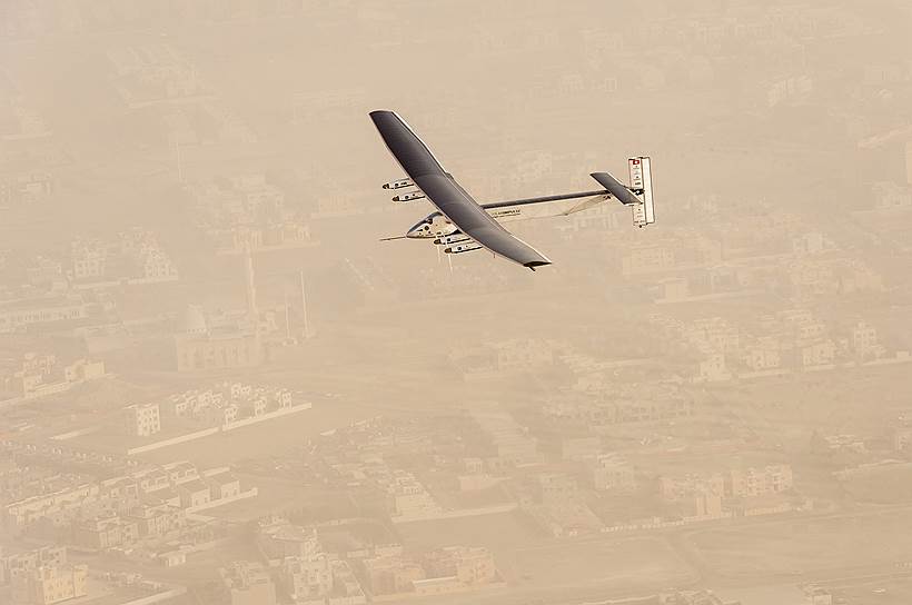 Абу-Даби, ОАЭ. Самолет на солнечных батареях Solar Impulse 2 над городом, откуда начался его кругосветный полет