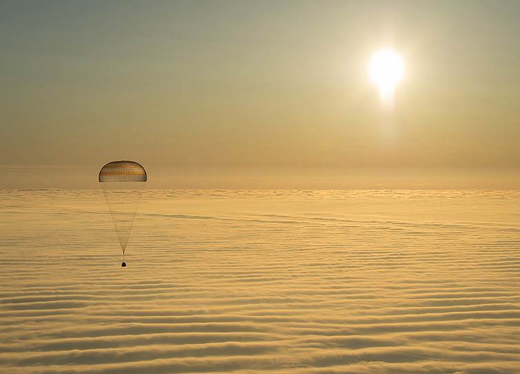 Казахстан. Спускаемый аппарат «Союз ТМА-14М» над облаками перед посадкой в окрестностях Жезказгана
