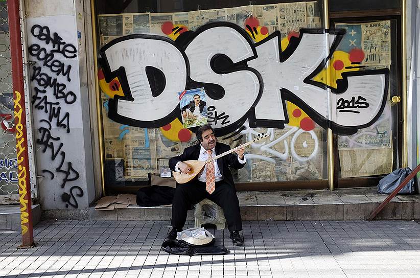 Стамбул, Турция. Уличный музыкант играет на сазе, традиционном восточном музыкальном инструменте 