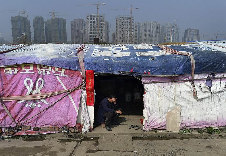 Хейфей, провинция Анхой, Китай. Фермер отдыхает в палатке на фоне строящихся небоскребов