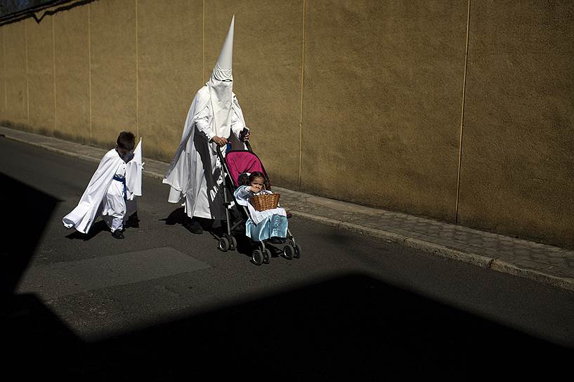 Севилья, Испания. Участник религиозного братства «Ла Пас» на пути в церковь, откуда начнется одно из традиционных шествий Страстной недели