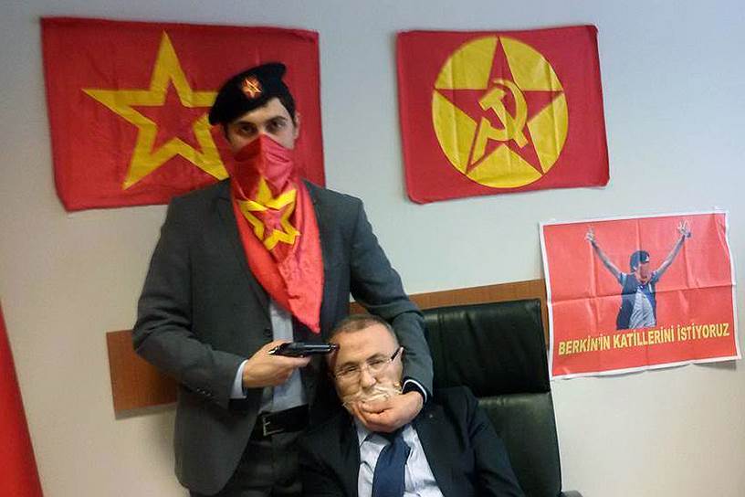 Стамбул, Турция. Прокурор Мехмет Селим Кираз, захваченный в заложники, на фоне флага группировки «Революционная народная освободительная партия — фронт» (DHKP-C)