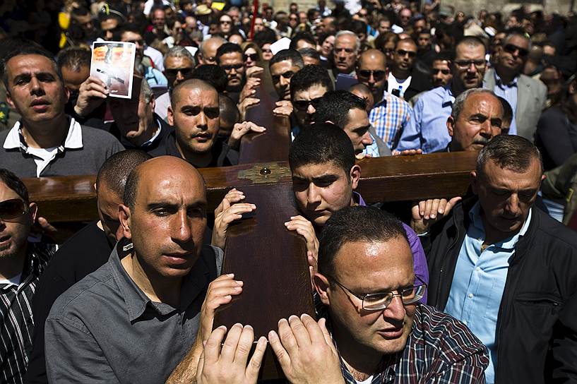 Христиане несут крест во время шествия по Виа Долороза в Страстную пятницу во время Страстной недели в Старом городе Иерусалима