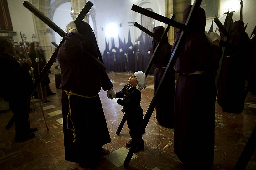 Ронда, юг Испании. Трехлетний мальчик в костюме косталеро — носильщика платформы с образами святых — вместе со своим дядей в церкви