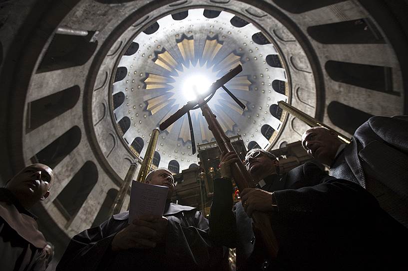 Члены духовенства принимают участие в молитве после процессии в церкви Гроба Господня в Великую пятницу во время Страстной недели в Старом городе Иерусалима