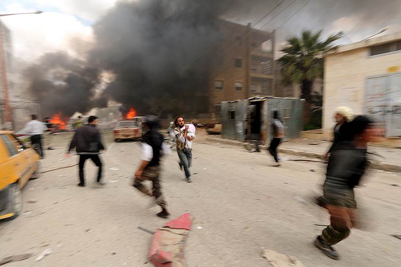 Идлиб, Сирия. Люди, бегущие после артиллерийского обстрела города силами, лояльными Башару Асаду