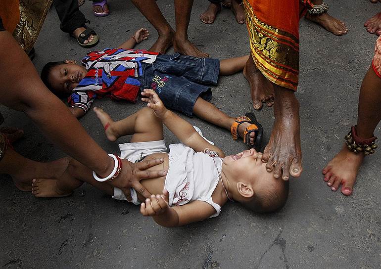 Калькутта, Индия. Индийский садху дотрагивается до ребенка ногой во время церемонии благословления