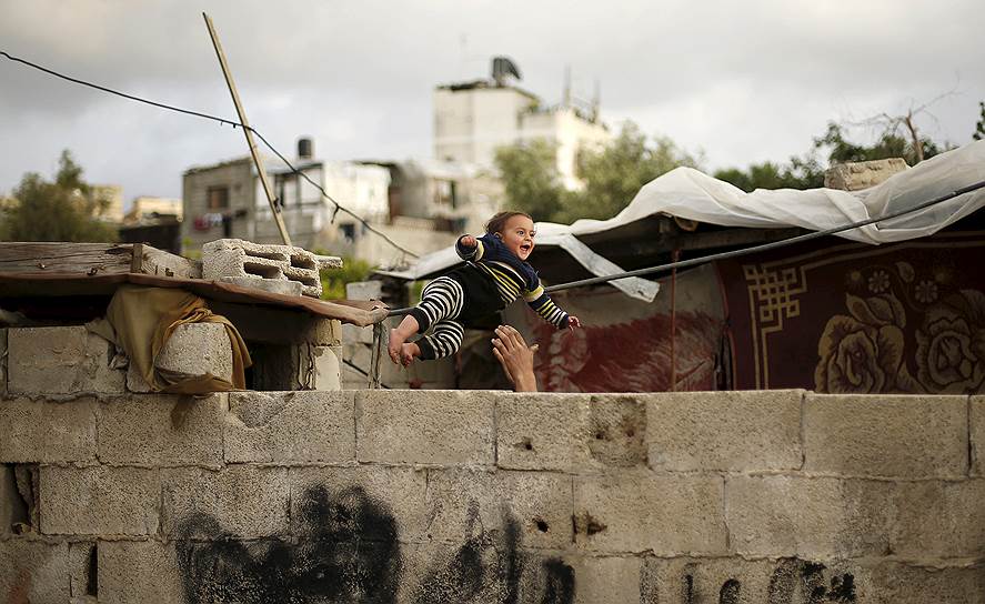 Бейт-Лахия, Палестина. Мужчина играет со своим сыном в развалинах их дома, разрушенного во время войны с Израилем