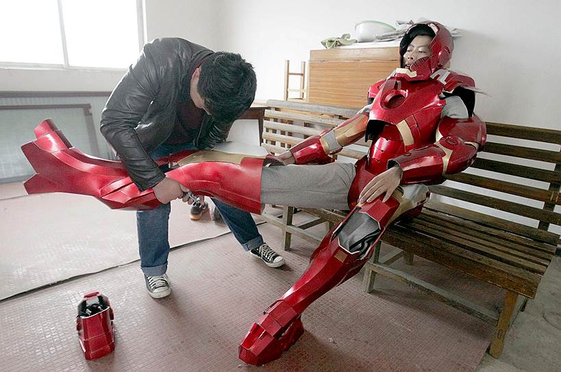 Сюйчжоу, Китай. 27-летний рабочий Чэн Чэнь (слева) помогает своему племяннику надеть самодельную копию костюма-брони Железного человека. На создание костюма, весящего около 4 килограммов, господин Чэнь потратил 500 юаней ($81)