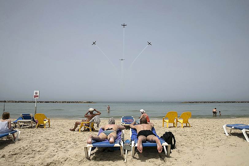 Тель-Авив, Израиль. Отдыхающие на пляже наблюдают за репетицией пилотажной группы израильских ВВС, которая готовится к выступлению на День Независимости Израиля