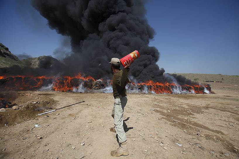 Шахкас, Пакистан. Солдат бросает бутылку с алгогольным напитком в огонь, где ранее в ходе операции были уничтожены 72 тонны гашиша, 110 кг героина, 179 кг опиума и 950 бутылок спиртного 