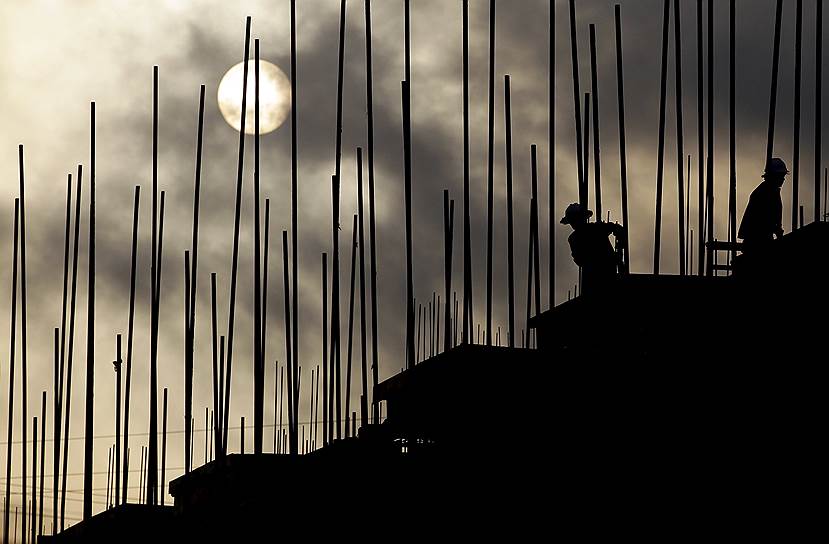 Пуэр, Китай. Рабочие с восходом солнца занимаются строительством жилого комплекса, чтобы решить проблему нехватки жилья