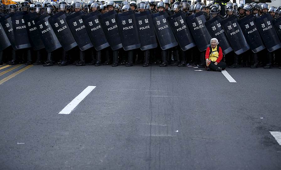 Сеул, Корея. Пожилая женщина возле оцепления полиции во время митинга Корейской конфедерации профсоюзов