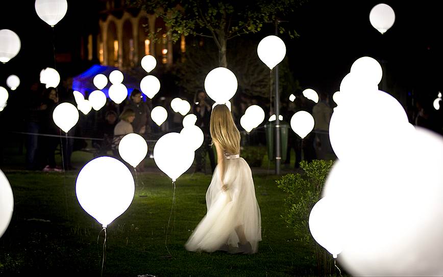 Бухарест, Румыния. Девушка гуляет среди шаров, являющихся частью световой арт-инсталляции