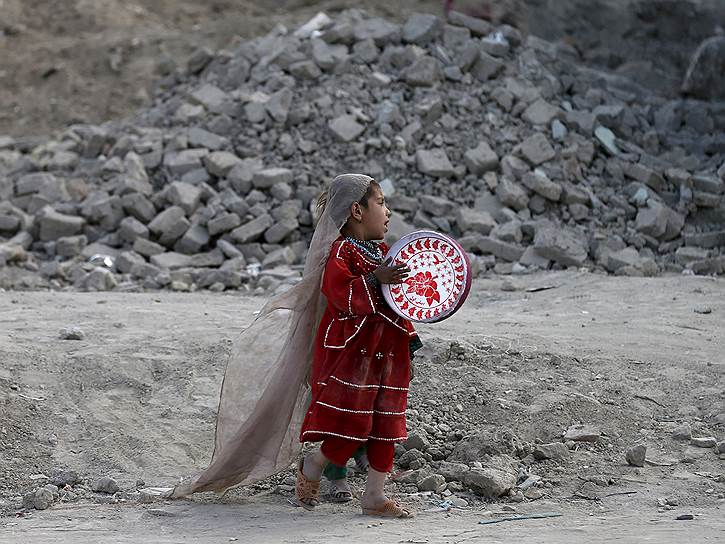 Кабул, Афганистан. Девочка играет на бубне недалеко от ее разрушенного дома 