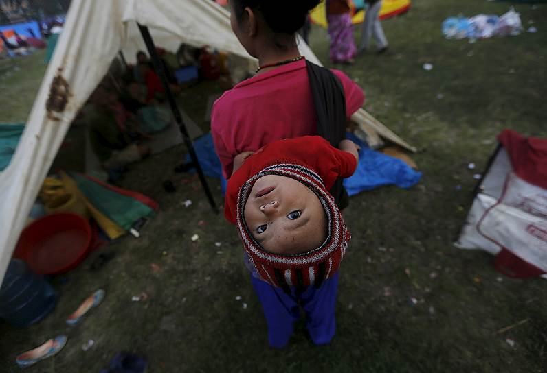 Катманду, Непал. Пострадавшая от землетрясения женщина с ребенком возле импровизированного убежища