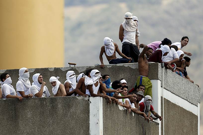 Каракас, Венесуэла. Заключенные собираются на крыше тюрьмы во время беспорядков