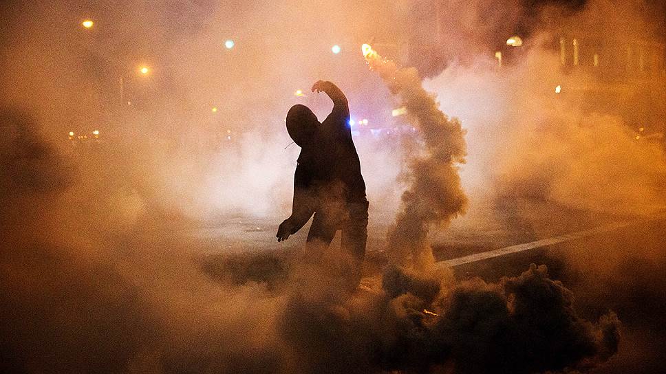 Балтимор, США. Протестующий бросает дымовую шашку в сторону полицейских