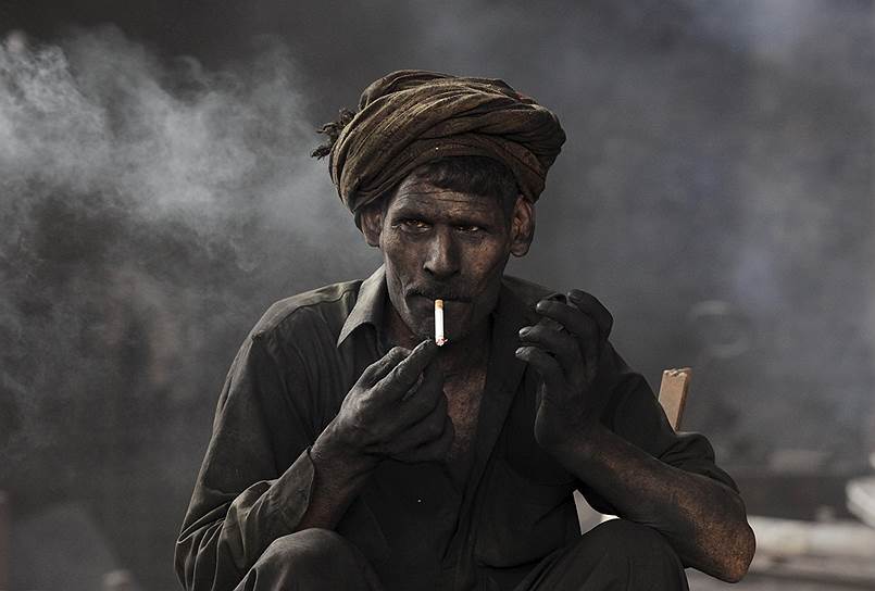 Лахор, Пакистан. Работник сталелитейного завода во время перерыва